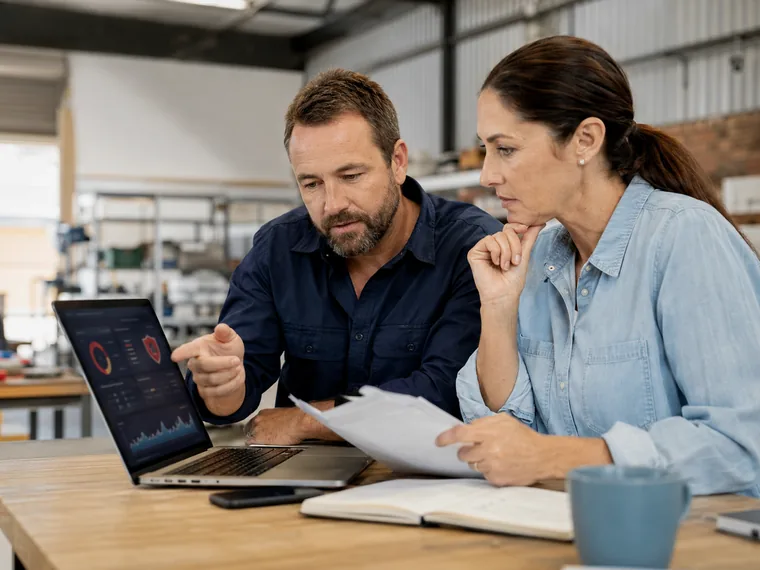Australian small business owners reviewing cyber risk information on a laptop