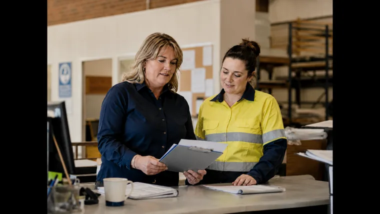 Australian employer and worker reviewing workplace information in a regional business
